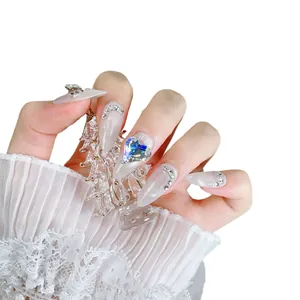 Faux ongles amande œil de chat avec strass blancs et cristal de cœur bleu scintillant