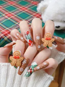 Détail de faux ongles de Noël avec un bonhomme de pain d'épices 3D et motifs de flocons