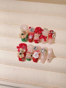 Detail of Christmas press-on nails featuring 3D reindeer, velvet bear and bow accents