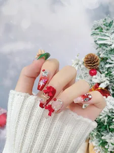 Detailed view of handmade Christmas press-on nails with 3D teddy bear and red bow designs