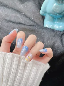 Detailed view of blue ombre nails with cute duck art and silver glitter tips