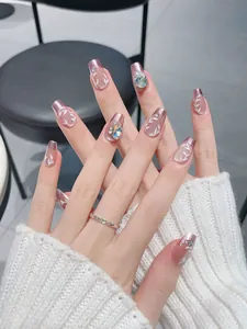 Detail of luxury press-on nails with rose gold mirror edges and hand-painted leaf patterns