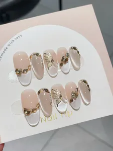 Details von handgefertigten Cat-Eye-Nägeln mit 3D-Gold-Schmetterling und Champagner-Strass
