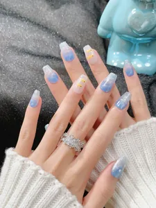 Detailed view of blue gradient press-on nails with cute duck pattern and silver glitter