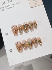 Detailed view of handmade press-on nails with heart rhinestones and champagne gems
