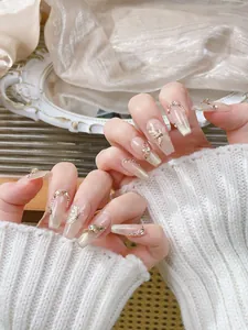 Detail of luxury handmade press-on nails with butterfly charms and cat-eye finish