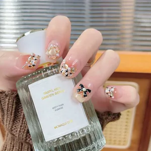 Handmade press-on nails with pearl, bow, and glitter accents in elegant pink nude tones