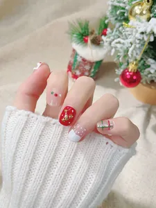 Detaillierte Nahaufnahme handgemachter Weihnachtsnägel mit rot-grün-goldener Festkunst