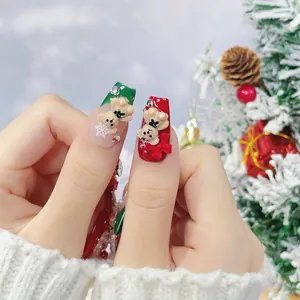 Handmade Christmas press-on nails featuring 3D bears, red bows, and festive snowflake art