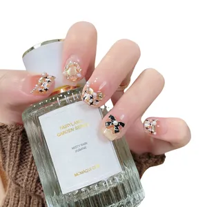 Elegant cat eye press-on nails with luxury pearls, bows and gold glitter details