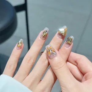 Handmade press-on nails with luxury heart crystals and butterfly design on nude base