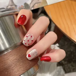 Handmade red cat eye press-on nails with heart patterns and glitter for New Year festival