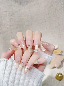 Detail of luxury press-on nails with 3D butterfly accents and golden glitter gradient