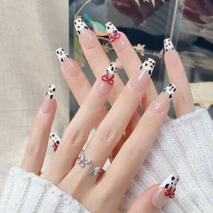 Handmade press-on nails with cappuccino cow pattern and red 3D bow accent decor