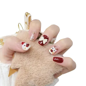 Handmade Christmas press-on nails featuring 3D white bow, Santa, and reindeer designs