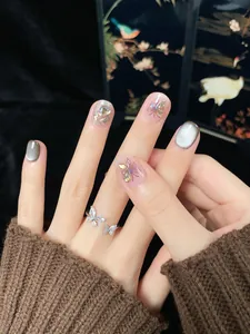 Detail of grey cat-eye nails with silver butterfly ring and sparkling zircon accents