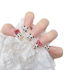 French press-on nails with cappuccino milk patterns and 3D red bow accents