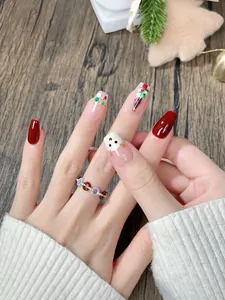 Detalle macro de uñas postizas navideñas con muñeco de nieve pintado a mano
