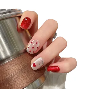 Short oval press-on nails in New Year red cat eye with heart and polka dot patterns