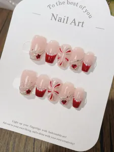 Detail of handmade red and white French press-on nails with 3D hearts and silver glitter