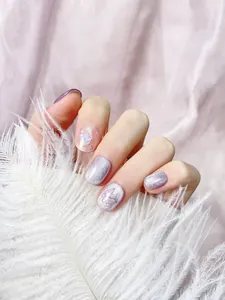 Dettaglio di unghie finte ovali corte con glitter viola e ciondoli a farfalla 3D