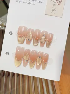 Detail of handmade cat eye nails with gradient nude tones, pearls and butterfly charms