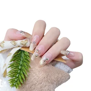 French press-on nails with nude pink base, champagne glitter, and 3D butterfly accents