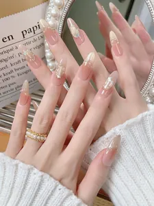 Detail of pink gradient press-on nails with pearls, rhinestones and butterfly charms