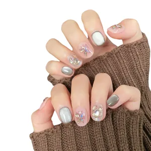 Sparkling cat-eye press-on nails with silver butterfly charms and rhinestones