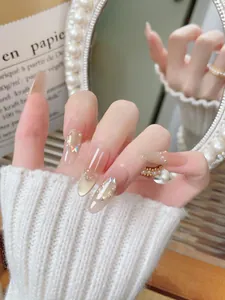 Detailed view of handmade cat-eye press-on nails with butterfly and pearl accents