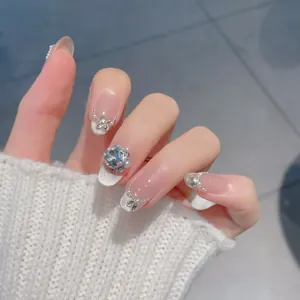 Handmade press-on nails with nude pink base, silver glitter French tips, and pearl accents