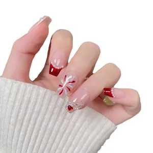 Red French tip press-on nails with fireworks patterns, pearls and a red heart gemstone