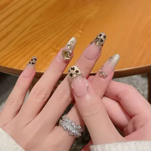 Handmade leopard print press-on nails with French gradient, gold glitter, and rhinestones