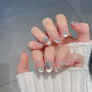 Handmade nude pink press-on nails with silver glitter gradient and pearl butterfly bows