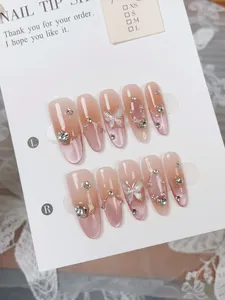 Macro view of pink gradient cat-eye press-on nails with butterfly and pearl charms