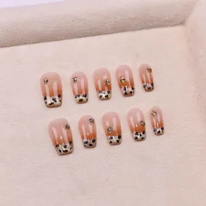 Détail de faux ongles œil-de-chat français avec motif léopard et touches de paillettes