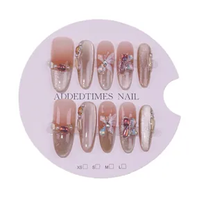 Handmade cat-eye press-on nails with butterfly and pearl accents in a pink gradient