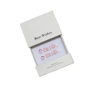 Handmade pink and white 3D cartoon press-on nail set with bows and donut charms in a box