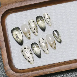Faux ongles œil-de-chat dorés avec étoiles peintes à la main et perles nacrées