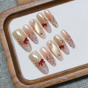 Handmade press-on nails with brown bow, cat-eye effect, pearls, and rhinestones