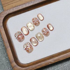 Handmade cat-eye press-on nails with champagne gold and tweed pearl bow designs