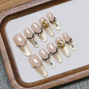 Champagne cat-eye press-on nails with French lines and glittering rhinestones