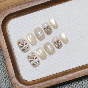 Handmade lion dance press-on nails with champagne gold cat-eye and 3D festive art