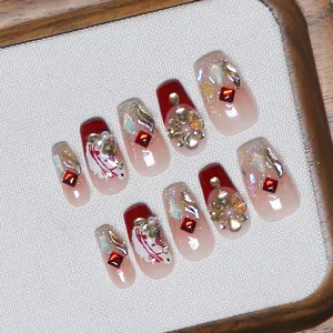 Macro shot of handmade wine red press-on nails with luxury crystals and floral art
