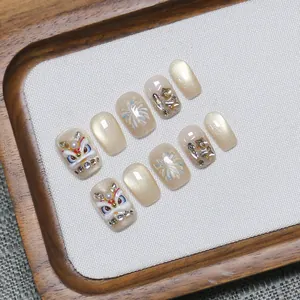 Handmade lion dance press-on nails with golden cat-eye effect and 3D festive designs
