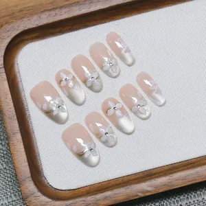 Handmade cat eye press-on nails with 3D floral accents and elegant pink gradient