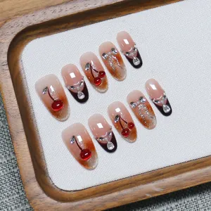 Handmade cherry cat-eye press-on nails with 3D crystal bows and pearls on wood tray