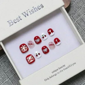 Handmade red and white New Year kids' press-on nails with lion dance design in a gift box