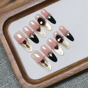 Handmade press-on nails in red and black shades with cat-eye glitter and heart gemstones