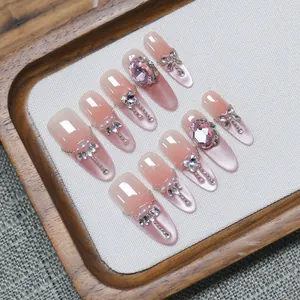 Handmade pink cat-eye press-on nails with luxury rhinestones and metal chain details